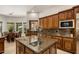 Beautiful kitchen with custom island, granite counters, and a view of the breakfast nook at 9417 E Charter Oak Dr, Scottsdale, AZ 85260