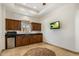 A convenient kitchenette with wood cabinets, granite countertop, a sink, a microwave, and a small refrigerator at 9417 E Charter Oak Dr, Scottsdale, AZ 85260