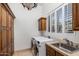 Laundry room with updated appliances, a large sink and plenty of storage at 9417 E Charter Oak Dr, Scottsdale, AZ 85260