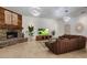 A spacious living room with a stone fireplace, travertine floors, modern lighting, and golf on television at 9417 E Charter Oak Dr, Scottsdale, AZ 85260