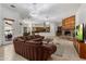 Expansive living room with a stone fireplace, travertine floors, modern lighting, and a golf channel TV at 9417 E Charter Oak Dr, Scottsdale, AZ 85260