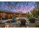 Outdoor pool and BBQ area create a beautiful and relaxing backyard retreat with lush landscaping and scenic sky at twilight at 9417 E Charter Oak Dr, Scottsdale, AZ 85260