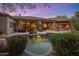 Inviting backyard featuring a swimming pool with lush greenery and a built-in outdoor kitchen for relaxation and entertaining at 9417 E Charter Oak Dr, Scottsdale, AZ 85260