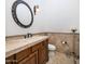 Elegant powder room with travertine floors, a custom vanity, a decorative mirror, and a wall-mounted light at 9417 E Charter Oak Dr, Scottsdale, AZ 85260