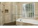 Elegant bathroom features a soaking tub, glass shower and a glass block window that provides natural light at 9540 N 114Th Way, Scottsdale, AZ 85259