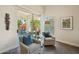 Cozy sitting area with stylish armchairs, and views of the lush backyard through large sliding glass doors at 9540 N 114Th Way, Scottsdale, AZ 85259