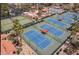 Aerial view of multiple tennis courts with blue playing surfaces, green surrounds, and sun shelters at 9708 E Via Linda -- # 1338, Scottsdale, AZ 85258