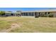A well-kept backyard featuring a sunroom addition, a quaint pergola, and mature landscaping at 9805 W Burns Dr, Sun City, AZ 85351