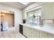Kitchen featuring a window with a view, white countertops and appliances and brick walls at 9805 W Burns Dr, Sun City, AZ 85351
