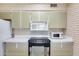 Kitchen featuring sleek appliances, white countertop, brick walls and light cabinets at 9805 W Burns Dr, Sun City, AZ 85351