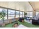Bright sun room with large windows, comfortable seating, and green flooring at 9805 W Burns Dr, Sun City, AZ 85351