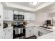 Bright kitchen features stainless steel appliances, sleek white cabinets, and modern countertops, creating a clean and functional space at 12201 S Paiute St, Phoenix, AZ 85044