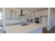 This bright kitchen features white cabinets, a large island, stainless steel appliances, and sleek countertops at 19117 W Missouri Ave, Litchfield Park, AZ 85340