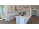 Bright kitchen features white cabinets, stainless steel appliances, and a large island with quartz countertop at 19117 W Missouri Ave, Litchfield Park, AZ 85340