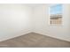 Minimalist bedroom with light carpet, white walls, and a window for natural light at 2680 E Santa Rosalia Dr, Casa Grande, AZ 85194