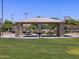 Outdoor pavilion with picnic tables and barbecue grill in a well-maintained park setting at 2680 E Santa Rosalia Dr, Casa Grande, AZ 85194