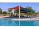 Community pool featuring shade sails, lounge chairs, and splash pad for residents' enjoyment at 2680 E Santa Rosalia Dr, Casa Grande, AZ 85194
