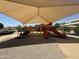 Well-maintained playground with a shade canopy, offering slides, climbing structures, and a safe play area at 2903 E Quenton St, Mesa, AZ 85213