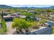 Custom home with lush trees and desert landscaping and a brick driveway in this lovely aerial view at 37334 N Winding Wash Trl, Carefree, AZ 85377