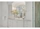 Elegant bathroom vanity with marble countertop, arched mirror, and custom white cabinetry at 37334 N Winding Wash Trl, Carefree, AZ 85377