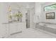 Bright bathroom showcasing marble floors, soaking tub, and vanity with arched mirror at 37334 N Winding Wash Trl, Carefree, AZ 85377