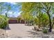 Spacious home featuring a paved driveway, three car garage, desert landscaping, and mature trees at 37334 N Winding Wash Trl, Carefree, AZ 85377