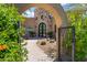 Charming home exterior features a stone tower, complemented by a brick walkway framed by mature desert landscaping and an arched gate at 37334 N Winding Wash Trl, Carefree, AZ 85377