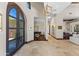 Light-filled foyer with travertine flooring, grand piano, designer lighting, and arched doorway provides a welcoming entrance at 37334 N Winding Wash Trl, Carefree, AZ 85377