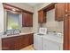 Laundry room with wooden cabinets and a sink by the window at 37334 N Winding Wash Trl, Carefree, AZ 85377