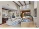 Open-concept living space with high ceilings, wood beam accents, and sliding glass doors leading to outdoor entertainment area at 37334 N Winding Wash Trl, Carefree, AZ 85377