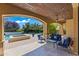 Comfortable covered patio with ceiling fan, stone accents, and beautiful views of the pool and garden at 37334 N Winding Wash Trl, Carefree, AZ 85377