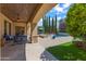 Inviting covered patio with a ceiling fan, stone pillars, comfortable seating, and pool views at 37334 N Winding Wash Trl, Carefree, AZ 85377
