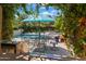 Inviting pool area with umbrella, dining table, chairs, and lush landscaping, perfect for outdoor gatherings at 37334 N Winding Wash Trl, Carefree, AZ 85377