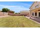 Expansive backyard featuring green grass, covered patio, and privacy block wall at 4422 E Dry Creek Rd, Phoenix, AZ 85044
