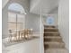 Open-concept dining room with stairs and a large window, showcasing natural light and space at 4422 E Dry Creek Rd, Phoenix, AZ 85044