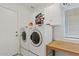 Functional laundry room with white washer and dryer, storage cabinets and folding table at 4422 E Dry Creek Rd, Phoenix, AZ 85044