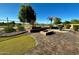 Backyard featuring manicured lawn, landscaping, and an outdoor fire pit at 702 E Capricorn Way, Chandler, AZ 85249