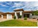 A charming home features a tile roof, a three car garage, and tidy landscaping at 702 E Capricorn Way, Chandler, AZ 85249