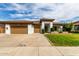 Inviting single-story home boasts a lush lawn, desert landscaping, and a three-car garage at 702 E Capricorn Way, Chandler, AZ 85249