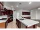 The spacious kitchen features an island with sink, stainless appliances, and dark wood cabinets at 702 E Capricorn Way, Chandler, AZ 85249