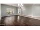 A spacious living room has hardwood floors, a view of the front yard, and overhead lighting at 702 E Capricorn Way, Chandler, AZ 85249