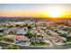 Sweeping aerial view of a residential area with manicured lawns, private pools, and the distant glow of the setting sun at 908 N Creston --, Mesa, AZ 85213