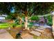 Lush backyard with large tree, play structure, outdoor kitchen and brick paver patio at 908 N Creston --, Mesa, AZ 85213