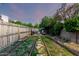 Backyard with mature trees, wooden fence, patio furniture, and garden beds at 908 N Creston --, Mesa, AZ 85213