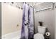 Bathroom with a tub and shower, a curtain with purple flowers, and a towel rack and toilet in the corner at 908 N Creston --, Mesa, AZ 85213