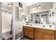 Bright bathroom with double sinks, oak cabinets, a large mirror, lavender accents, and a shower/tub combo at 908 N Creston --, Mesa, AZ 85213