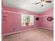 Bedroom with pink walls, ceiling fan, window with white shutters, and neutral-colored carpet is ready for décor at 908 N Creston --, Mesa, AZ 85213