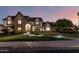 Charming two-story Tudor-style home featuring a brick facade and well-manicured lawn with accent lighting at 908 N Creston --, Mesa, AZ 85213