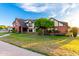 Attractive two-story home showcasing a brick facade, green lawn, and mature tree at 908 N Creston --, Mesa, AZ 85213