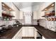 Charming kitchen featuring custom cabinets, striking backsplash, wooden countertops, and open shelving for coffee mugs and wine glasses at 908 N Creston --, Mesa, AZ 85213